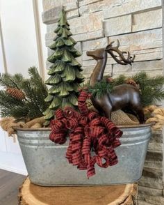 a metal tub filled with christmas decorations next to a brick wall and tree stumps