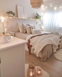 a bedroom with white walls and lights on the ceiling, a bed covered in blankets