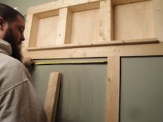 a man standing in front of some unfinished cabinets