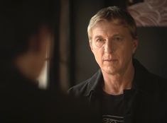 a man in black shirt looking at another person