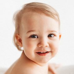 a close up of a baby smiling at the camera