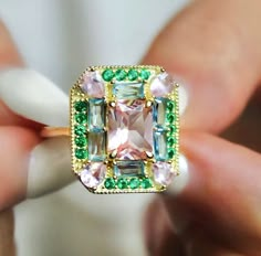 The Emerald Morganite 1930s Era Art Deco Cocktail ring features lab created Morganite, Emerald & Aquamarine gemstones on a vintage rectangle setting. She makes a statement with a mix of fancy gemstone cuts; baguettes, pear cut, radiant cut. The setting is comfortable, low profile and sits flush to the finger. Get ready for compliments! Lab Created Gemstones: Morganite, Emeralds & Sky Blue Topaz Metal: 14k Gold Vermeil (Sterling Silver base) Dimensions: 18mm x 15mm Band Width: 1.8mm Hypoallergeni Art Deco Cocktail, Dope Jewelry, Sky Blue Topaz, Jewelry Studio, Jewelry Lookbook, Bling Rings, Radiant Cut, Jewelry Inspo, Dream Jewelry