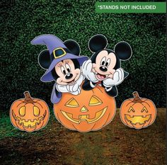 mickey and minnie mouse standing next to each other with pumpkins in front of them