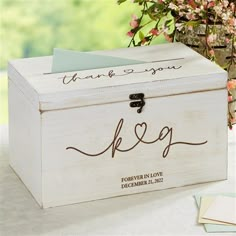 a white wooden box with writing on it and a flower pot behind it that says, thank you k e p