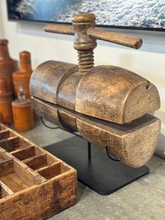 an old wooden grinder sitting on top of a table next to other woodworking tools