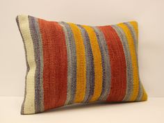 a multicolored striped pillow sitting on top of a white table