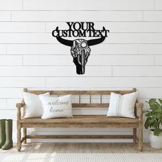 a wooden bench sitting in front of a white wall with a cow's head on it