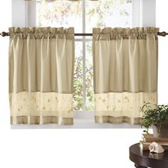 the curtains are hanging on the window sill in front of the table and potted plant