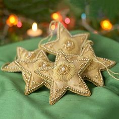 four gold star ornaments sitting on top of a green cloth