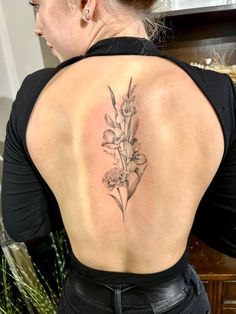 a woman with a tattoo on her back and flowers in the upper part of her body