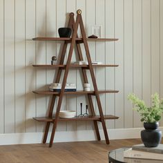 a wooden shelf with books and vases on it