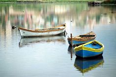 two small boats floating on top of a lake