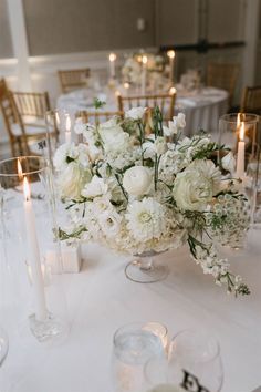 white flowers and candles are on the table in this elegant wedding reception centerpieces