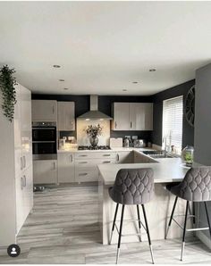 a kitchen with two bar stools next to an island