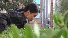 a woman is in the grass blowing her nose