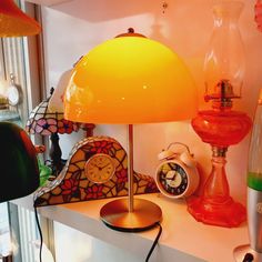 an assortment of lamps and clocks on a shelf