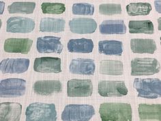 some blue and green paint squares on a white surface with watercolor stains all over it