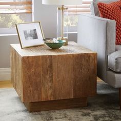 a living room with a chair, table and pictures on the end table in front of it