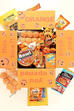 an orange box filled with snacks and candies