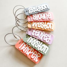 Kids Backpack or Lunchbox Tag : . : . : ITEM DETAILS : . : . : Tag is approx. 3.5" wide. Name will be in white acrylic in the font shown. Select one color for the background of the tag. In the personalization box, please leave the name you would like on the tag. Comes with a cable wire keyring.  Laser cut from acrylic. IMPORTANT: These bag tags are made from acrylic, which is a hard plastic. Please handle with care. If dropped or banged against a hard surface, they most likely will break. We are Shrink Plastic Name Tags, Cricut Bag Tag Baby, Cricut Tags Bags Boxes And More, Kids Backpack Tags, Acrylic Projects, Kids Bag Tags, Keychain Acrylic, Keychain Craft, Acrylic Bag