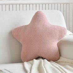 a pink star pillow sitting on top of a white couch