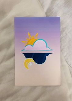 a card with the sun and moon on it sitting on top of a white sheet