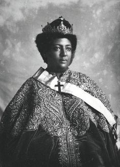 an old black and white photo of a woman wearing a crown with a cross on it