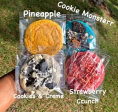 four different cookies and cremes in plastic bags on the grass with words that read pineapple, pineapple, cookie monster, cookies, cookies & creme strawberry crunch