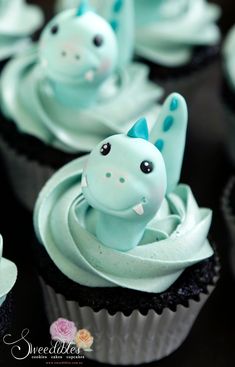 cupcakes decorated with blue frosting and an animal figurine