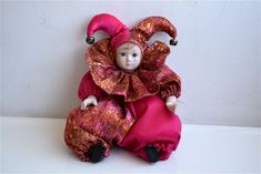 a doll is dressed in pink and gold