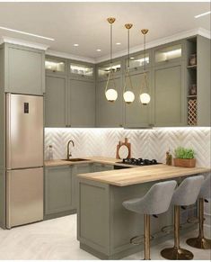 an image of a kitchen setting with green cabinets and gold accents on the countertops