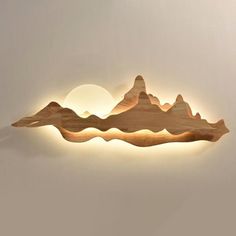 a wooden wall light with mountains on the side and a full moon in the background