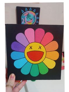 a hand holding up a card with an image of a flower painted on the front