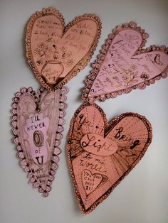 three pink hearts with writing on them