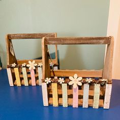 two wooden frames with flowers are sitting on a blue table