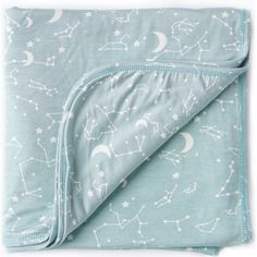 a blue blanket with white stars and moon prints on it, folded up to the side