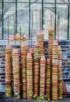 stacks of clay pots sitting in front of a window