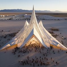 an aerial view of people standing in front of a large building with a triangular roof