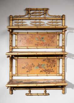 three bamboo shelves with paintings on them