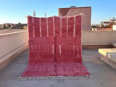 two red rugs sitting on top of a roof