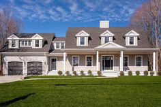 a large white house with two garages on the front and one story above it