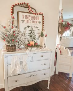 a white dresser with christmas decorations on top and pine wood tree farm sign above it