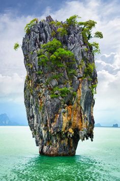 an island in the ocean with trees growing out of it