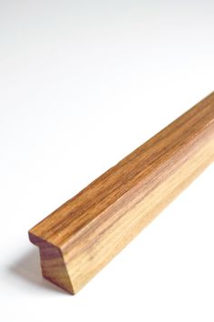 a close up of a wooden object on a white surface