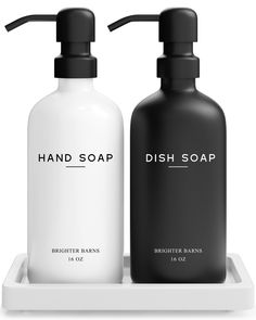 two black and white soap bottles sitting on a tray with the words dish soap next to each other