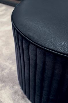 a close up view of a black leather stool