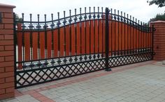 an iron fence with brick pillars and gates