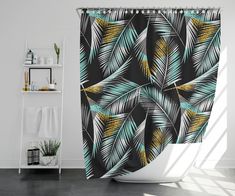 a shower curtain with tropical leaves on it in a white bathtub next to a shelf