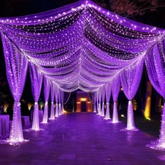 an outdoor wedding venue decorated with purple lights