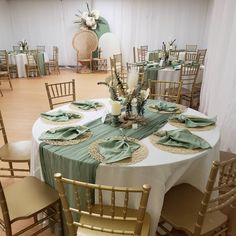 the table is set with green napkins and place settings for guests to sit at